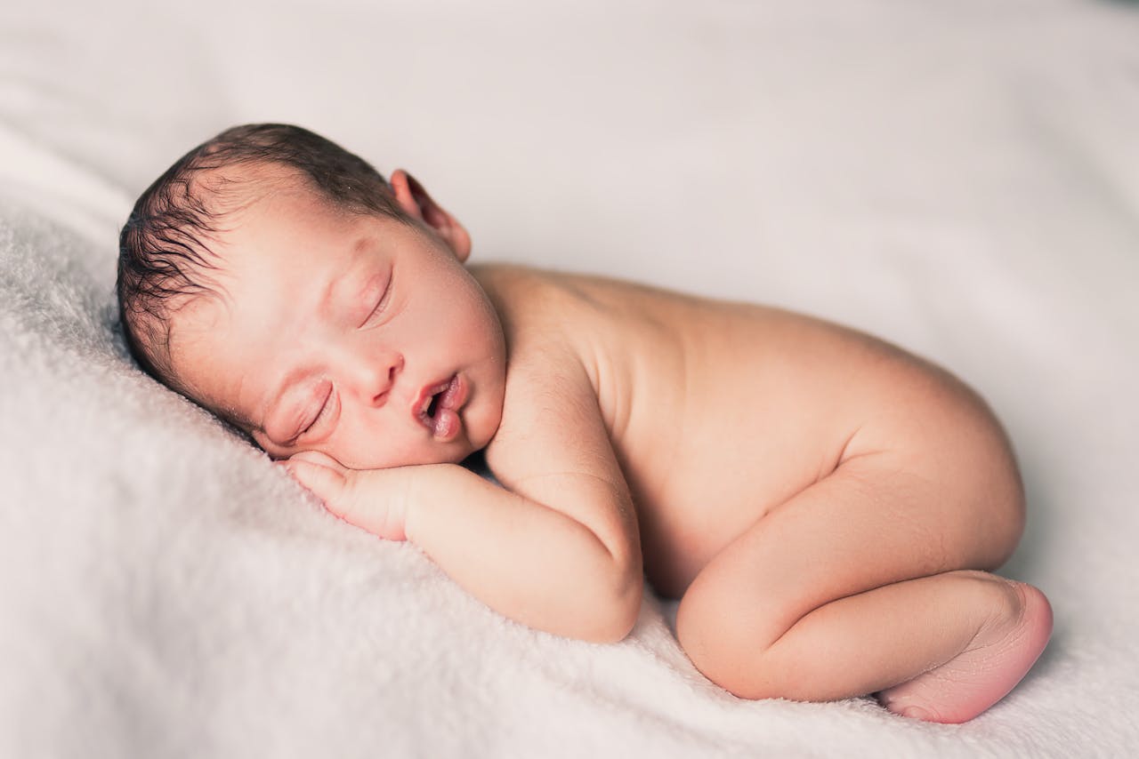 Photo of a Lying Newborn on a White Sheet